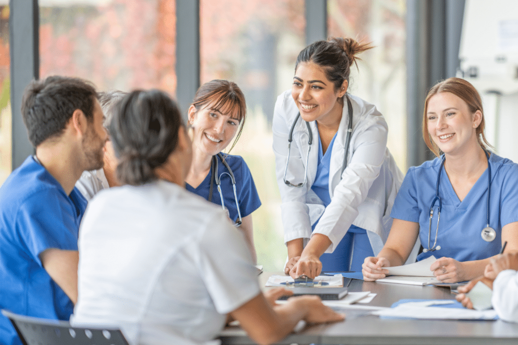 young doctors in lab coats with one of them instructing leading the group