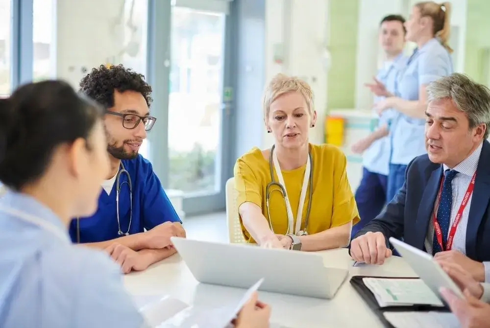 medical professionals sitting around a table having a discussion