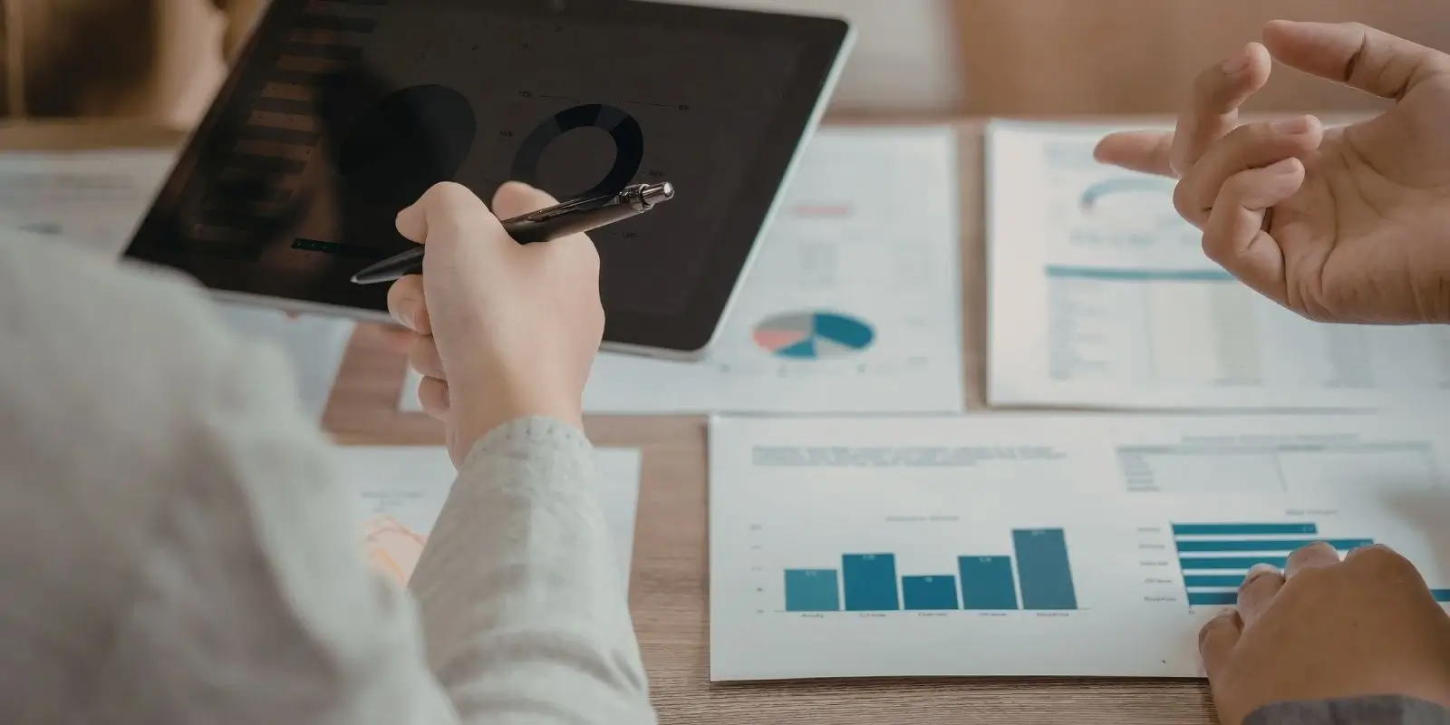 individual shown reviewing documents and signing tablet
